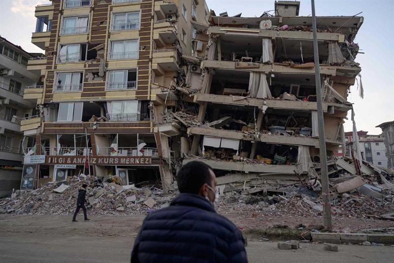 A man looks up at a collapsed building in Hatay, southern Turkey on February 19, 2023. AFP