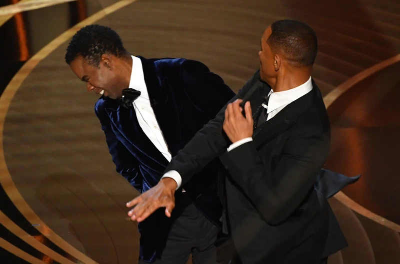 US actor Will Smith, right, slaps actor and comedian Chris Rock onstage during the 94th Oscars at the Dolby Theatre in Hollywood, California on 27 March 2022. Image: Robyn Beck / AFP)