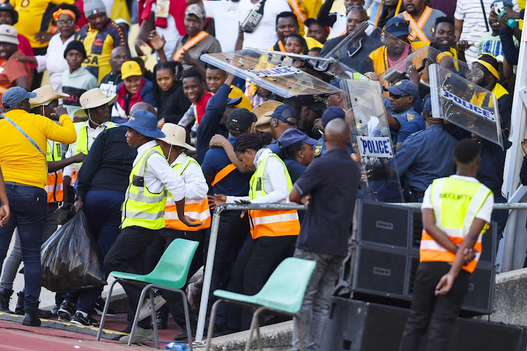 Kaizer Chiefs coach Arthur Zwane and players run for cover as their fans hurl objects at them after their 1-0 loss to SuperSport United at Royal Bafokeng Stadium. Image: Lefty Shivambu/Gallo Images