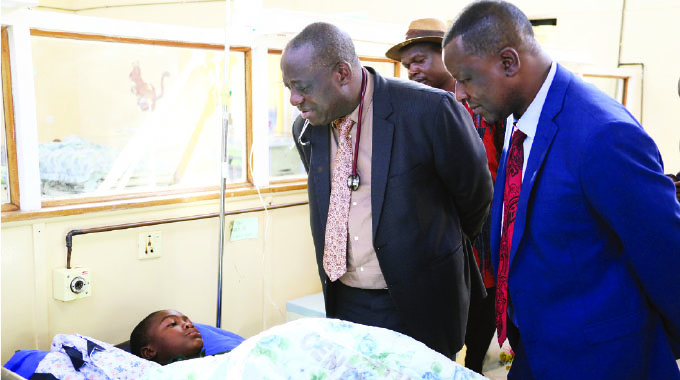 Health and Child Care Deputy Minister Dr John Mangwiro (left) and Traffic Safety Council of Zimbabwe managing director Mr Munesuishe Munodawafa check on one of the Harare-Masvingo Road accident victims, Ashley Muringayi, at Chitungwiza Central Hospital yesterday. - Picture : Justin Mutenda