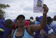 A mourner displays a flier at slain CCC activist Moreblessing Ali's funeral